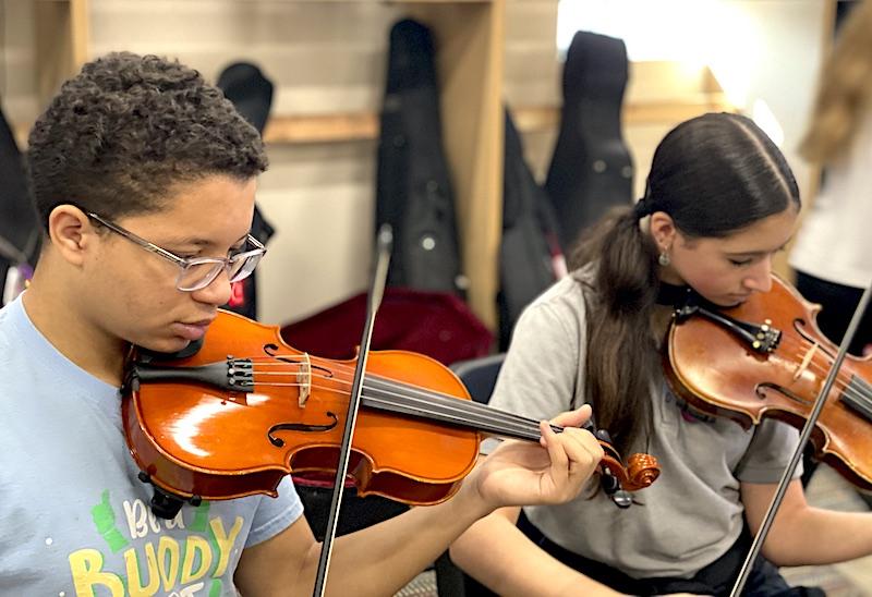 Two Parker Performing Arts middle schoolers – a boy and a girl -- are practicing violin.