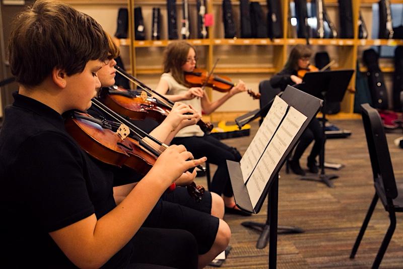 Parker Performing Arts School middle schoolers practice violin in preparation for a public performance.